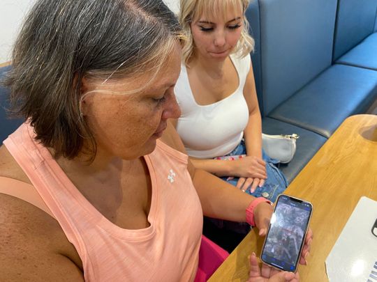 Heather MacKay (L), 48, and daughter Meliah MacKay, 18, speak to AFP in Kelowna, British Columbia, Canada, on August 21, 2023, as Heather shows an aerial picture of her house. 