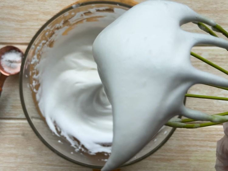 Whip the whipping cream in a large chilled bowl using a hand blender until it reaches stiff peaks.