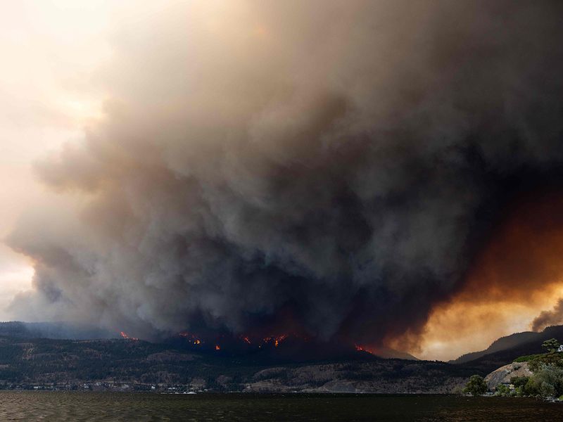 The McDougall Creek wildfire burns in the hills in West Kelowna, British Columbia, Canada, on August 17, 2023, as seen from Kelowna. 