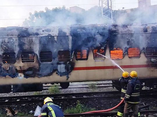 Firefighters try to extinguish a fire which broke out in a train coach parked at the Madurai railway yard, in Madurai on August 26, 2023.  