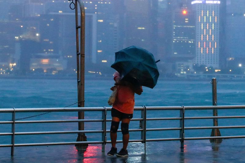 A person with an umbrella struggles against strong wind and rain brought by typhoon Saola in Hong Kong, on Friday, Sept. 1, 2023. Most of Hong Kong and other parts of southern China ground to a near standstill Friday with classes and flights canceled as powerful Typhoon Saola approached.