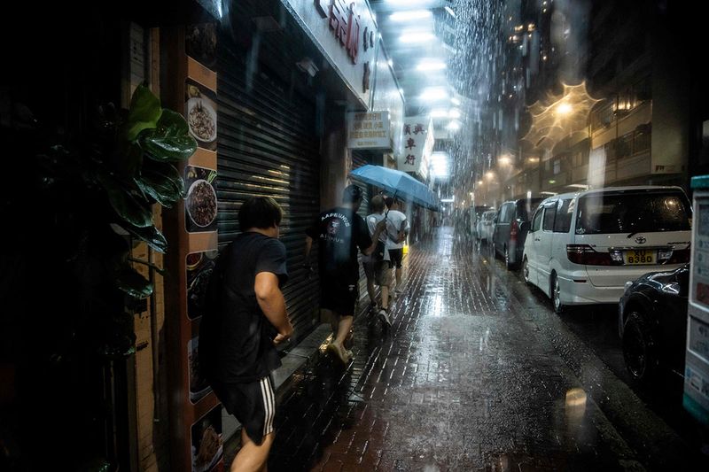 People are seen on the street during Super Typhoon Saola in Hong Kong on September 1, 2023. Super Typhoon Saola threatened southern China on September 1 with some of the strongest winds the region has endured, forcing the megacities of Hong Kong and Shenzhen to effectively shut down.