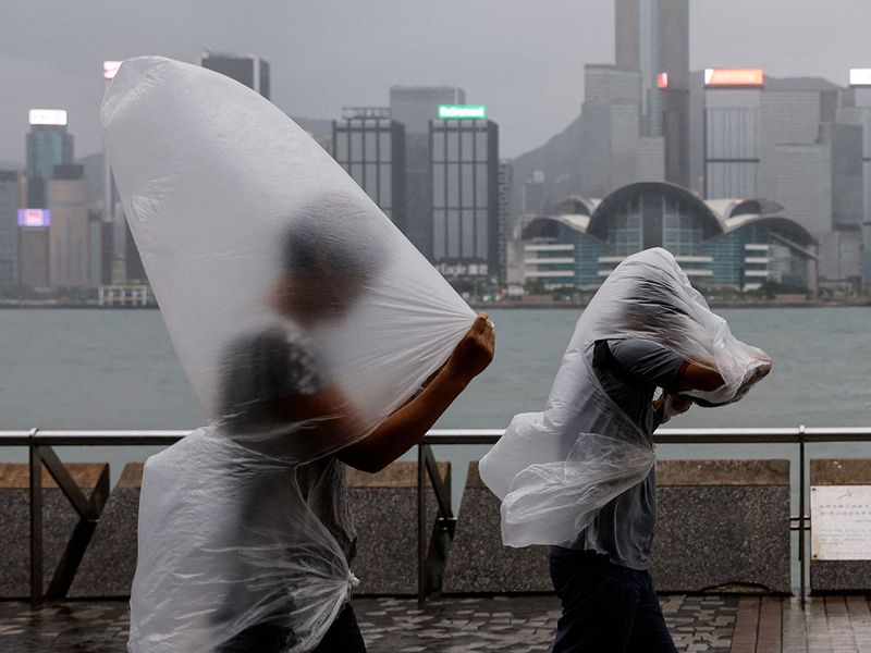 People brave strong winds as Super Typhoon Saola approaches, in Hong Kong, China September 1, 2023.