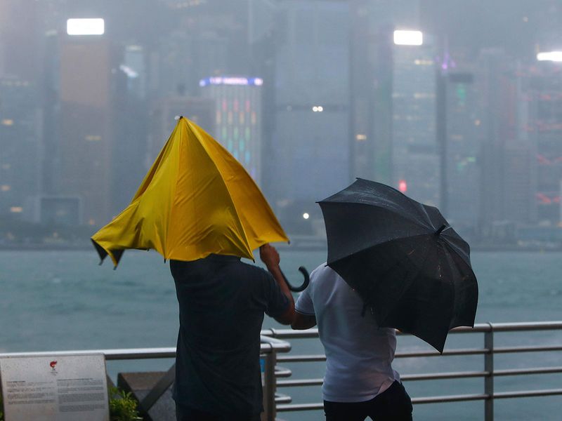 People with umbrellas struggle against the strong wind and rain brought by super typhoon Saola in Hong Kong, on Friday, Sept. 1, 2023. Most of Hong Kong and other parts of southern China ground to a near standstill Friday with classes and flights canceled as powerful Typhoon Saola approached. 