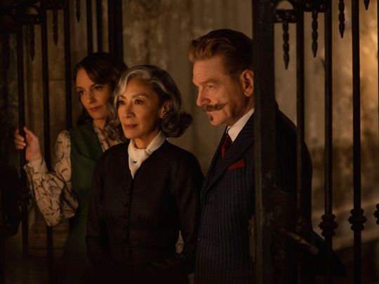Tina Fey as Ariadne Oliver, Michelle Yeoh as Mrs. Reynolds, and Kenneth Branagh as Hercule Poirot in 'A Haunting in Venice'.