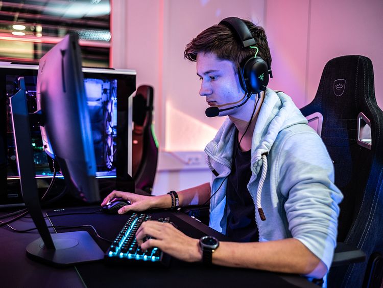 Adult playing video games on monitor with mouse and headphones. Gamer using  mousepad and headset to play online games on computer. Player having fun  with gaming and electronic game Stock Photo