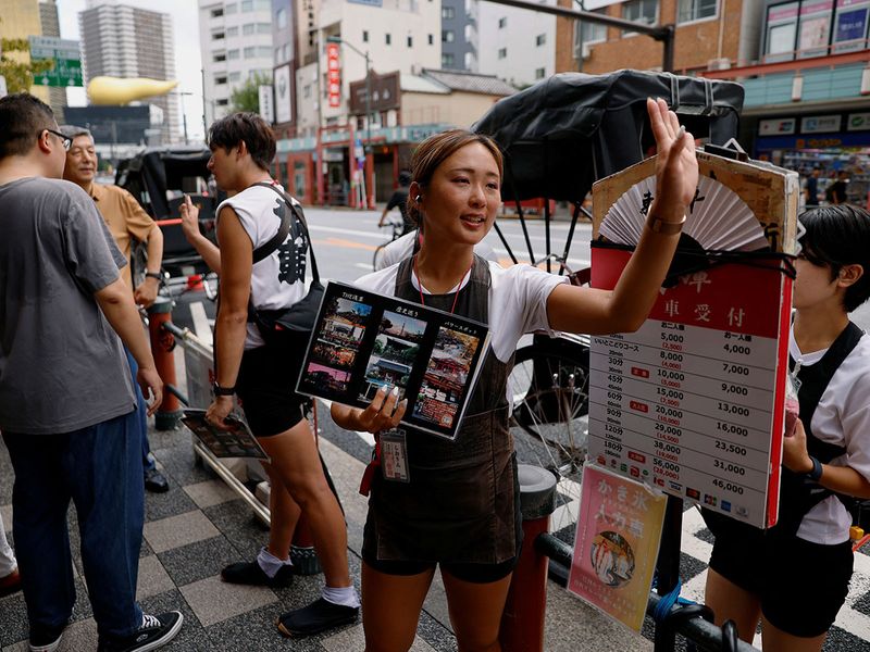 Rickshaw puller Shiori Yoshida, 28, attracts tourists to the guided tour at the Asakusa district in Tokyo, Japan, August 22, 2023. 