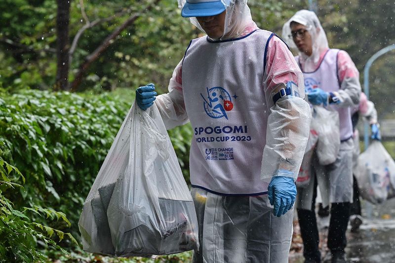 Participants carry bags of trash during the Japan stage of the 