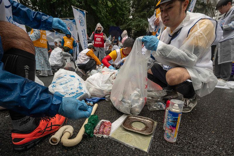 Participants sort trash they picked up while taking part in the Japan stage of the 