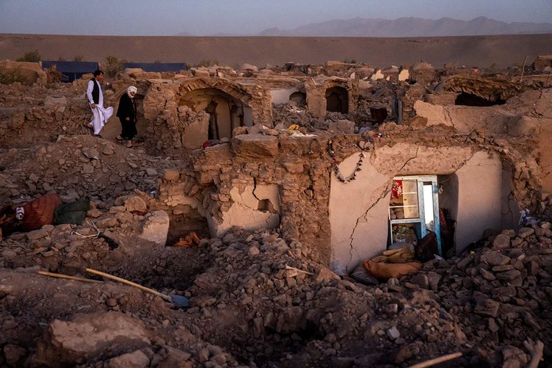  Afghan men search for victims after an earthquake in Zenda Jan district in Herat province, of western Afghanistan, Sunday, Oct. 8, 2023.