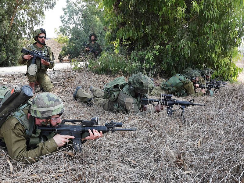 Israeli soldiers take position in Kfar Aza, south of Israel bordering Gaza Strip, on October 10, 2023.  