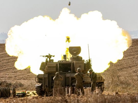 An Israeli army self-propelled howitzer fires rounds near the border with Gaza