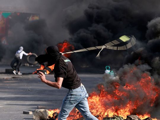 A Palestinian uses a slingshot during clashes with Israeli soldiers at the north entarnce of the city of Ramallah, near Beit El Jewish settlement, in West Bank 