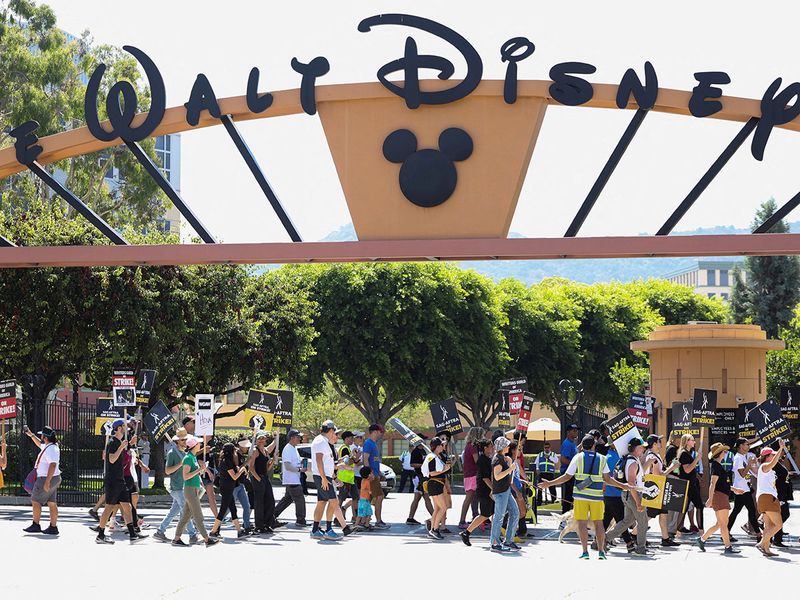 FILE PHOTO: SAG-AFTRA actors and Writers Guild of America (WGA) writers walk the picket line during their ongoing strike outside Walt Disney Studios in Burbank, California, U.S., August 22, 2023