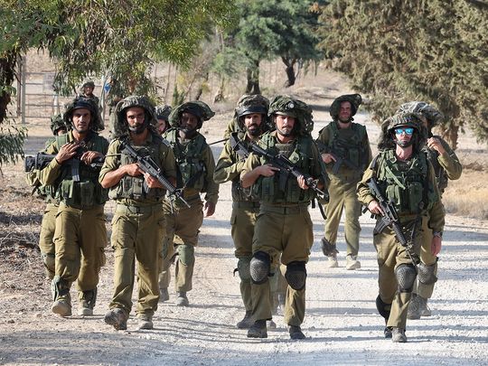 Israeli troops patrol at an undisclosed location along the border with the Gaza Strip on October 19, 2023.  