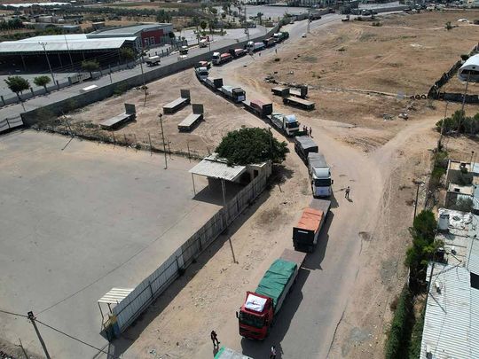 In this aerial view, a convoy of lorries carrying humanitarian aid enter the Gaza Strip from Egypt via the Rafah border crossing on October 21, 2023.
