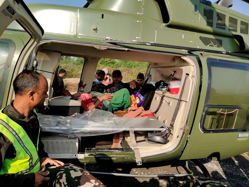 An injured person is seen inside a helicopter after an earthquake in Jajarko