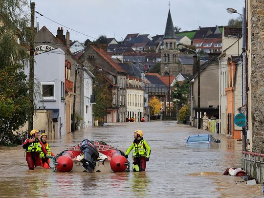 French firefighters walk on a flooded street