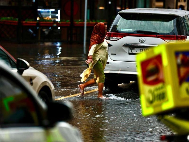 Pedestrians struggle to navigate through heaving water clogging in Oud Metha