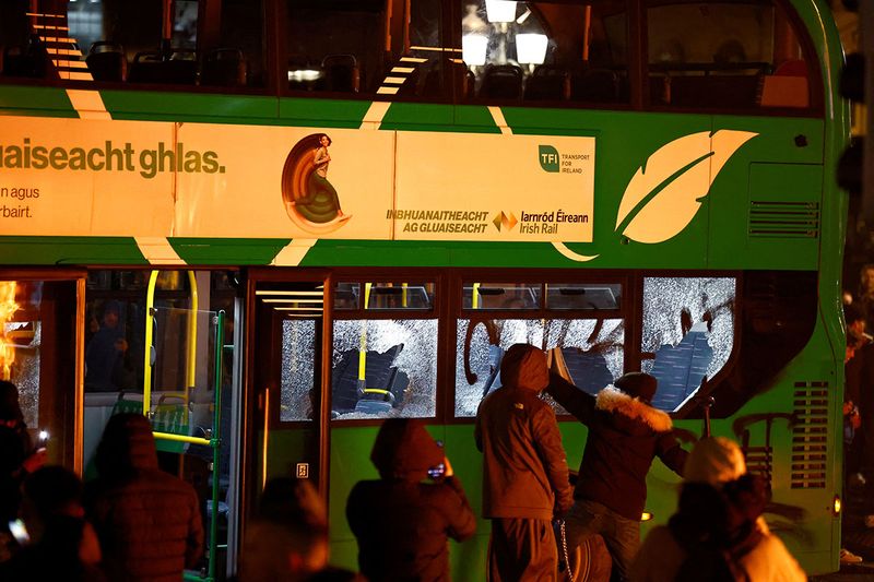 People break windows of a buss during a demonstration following of a suspected stabbing that left few children injured in Dublin, Ireland, November 23, 2023. 