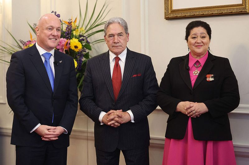 L-R) New Zealand's new Prime Minister Christopher Luxon, New Zealand's Deputy Prime Minister Winston Peters, and New Zealand's Governor General Dame Cindy Kiro attend the swearing-in of the new government at Government House in Wellington on November 27, 2023. Former airline boss Christopher Luxon formally took office as New Zealand's prime minister on November 27, vowing to tame inflation and bring down interest rates. (Photo by Marty MELVILLE / AFP)