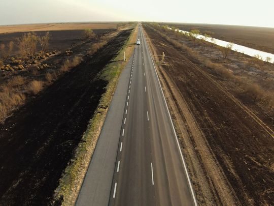 The road linking the provinces of Santa Fe and Entre Rios surrounded by burned land during wildfires in Rosario, Argentina