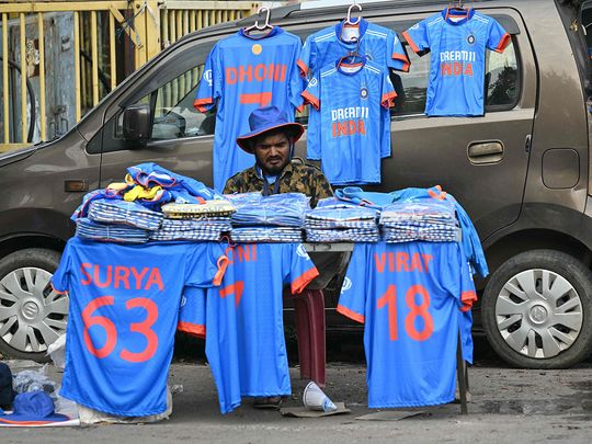 A vendor selling jerseys with names of Indian cricketers wait for customers in Raipur on November 30, 2023.