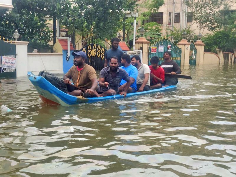 People use a boat to shift to a safer place from a flooded area after heavy rainfall owing to Cyclone Michaung, in Chennai on Tuesday.