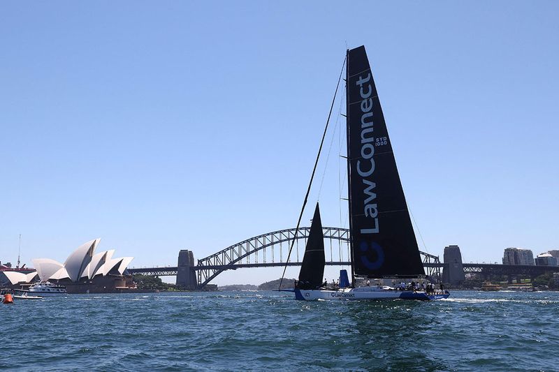 Christian Beck's Law Connect crosses the finish line in front of the Harbour Bridge during the SOLAS Big Boat Challenge in Sydney on December 5, 2023. (Photo by Saeed Khan / AFP) / -- IMAGE RESTRICTED TO EDITORIAL USE - STRICTLY NO COMMERCIAL USE --