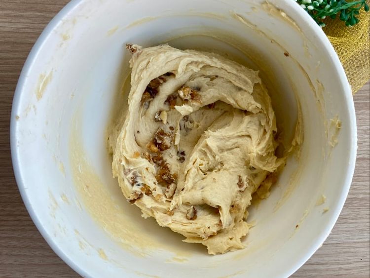 Preheat the oven to 170°C to 180°C. Whisk butter, sugar, and caramel flavouring in a bowl until light and creamy. Add eggs, then fold in flour, baking powder, and caramelised walnuts.