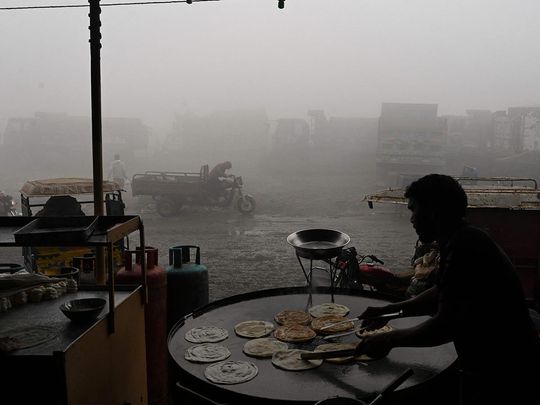 A man makes bread along a road amid heavy smog in Lahore 
