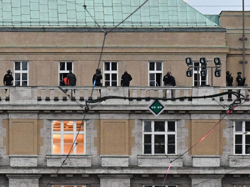 Armed police are seen on the balcony of the university in central Prague, on December 21, 2023.  