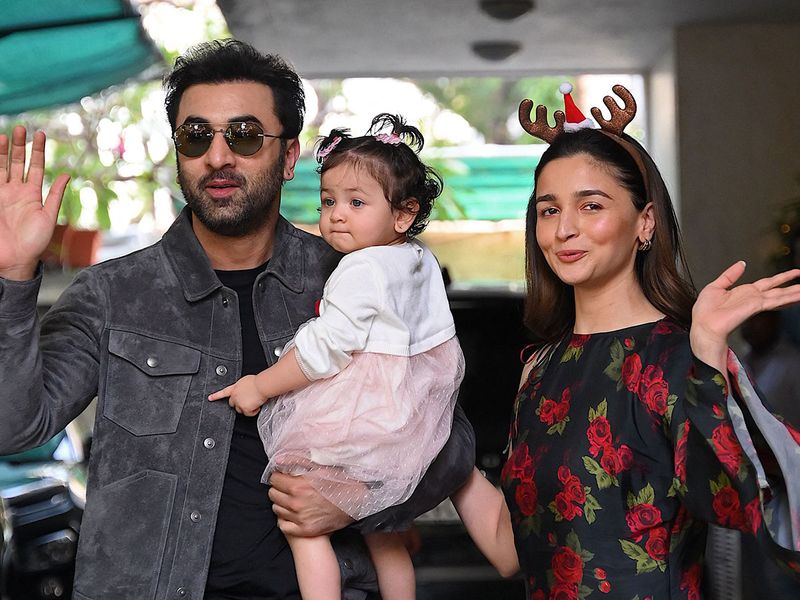 Bollywood actors Ranbir Kapoor (L) and his wife Alia Bhatt pose with their daughter Raha upon their arrival for a Christmas brunch in Mumbai on December 25, 2023. (Photo by Sujit JAISWAL / AFP)