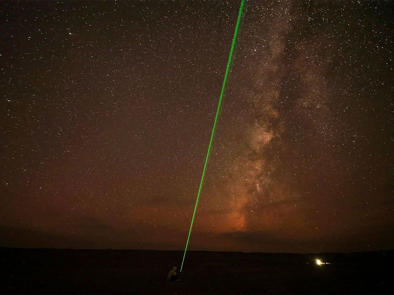 A man uses laser light toward the sky as the Milky Way galaxy is seen in the sky around camp in the natural reserve area of Wadi Al-Hitan, or the Valley of the Whales, at the desert of Al Fayoum Governorate, southwest of Cairo, Egypt, August 12.