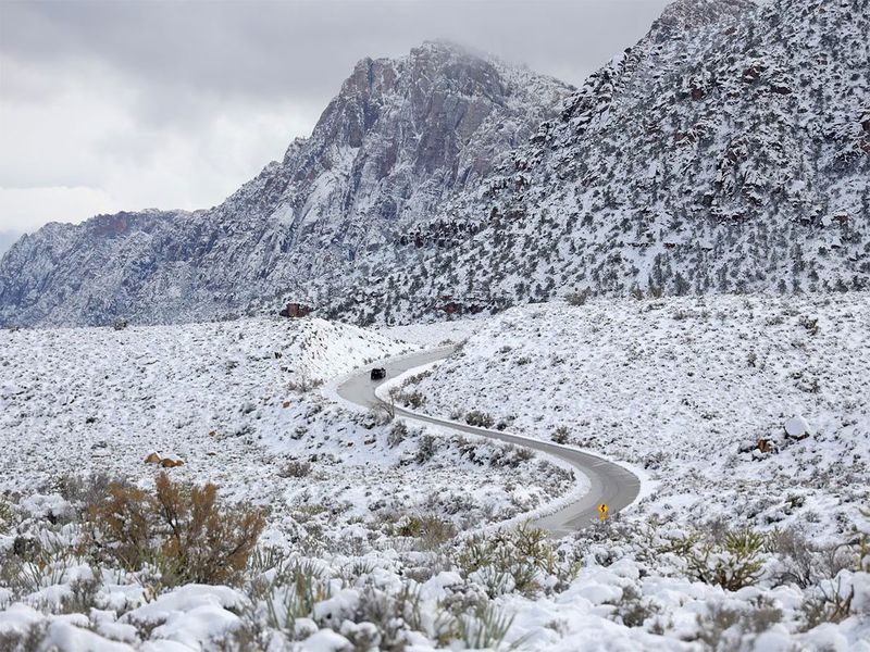 A vehicle drives through a snowy landscape along the Red Rock Canyon National Conservation Area's scenic loop drive in Clark County near Las Vegas, Nevada, March 1.