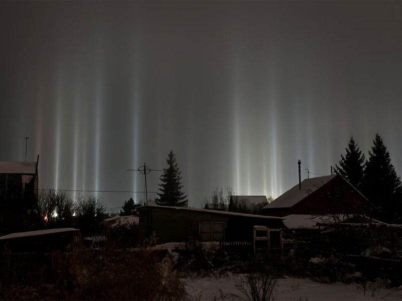 Pillars of light, which are optical atmospheric phenomena, beam up from the ground into the sky behind residential buildings in Omsk, Russia, January 2.