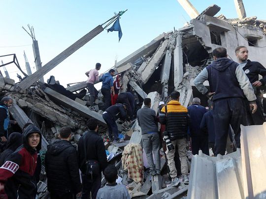 Palestinians inspect the damage following Israeli strikes on the Zawayda area of the central Gaza Strip on December 30, 2023. 