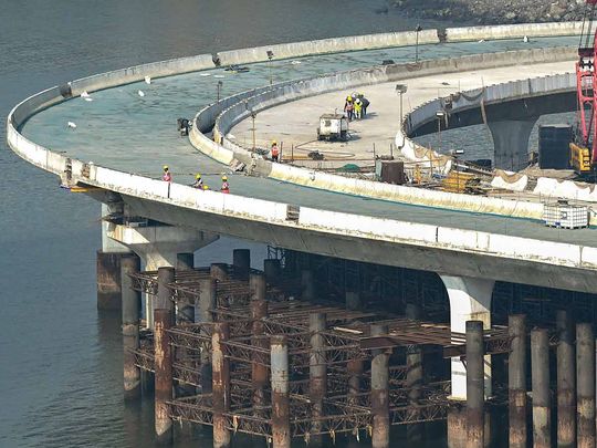 Labourers work on an under construction portion of the Coastal Road expressway along the Arabian Sea coastline of Mumbai on December 29, 2023.