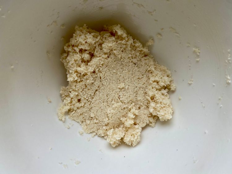 add desiccated coconut to the egg mixture and mix it using a spatula until the dough comes together. 
