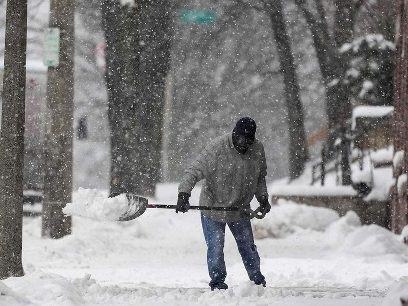 A man shovels as a winter storm arrives on Friday, in Milwaukee. 