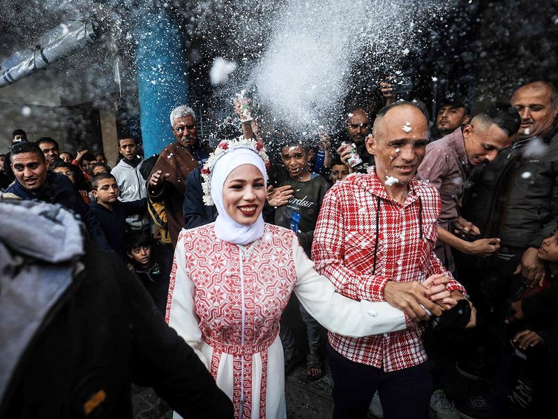 Palestinian bride Afnan Jibril (C) is escorted by her father (C-R) during her wedding