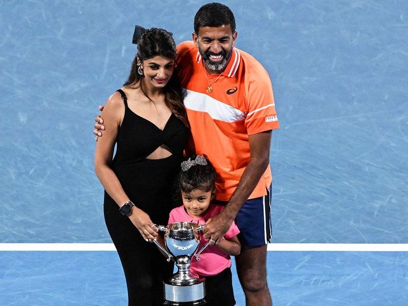 India's Rohan Bopanna poses with his family after victory against Italy's Simone Bolelli and Andrea Vavassori during their men's doubles final match on day 14 of the Australian Open tennis tournament in Melbourne on January 27, 2024. 