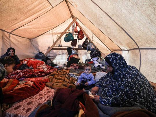 Members of a displaced Palestinian family sit inside a tent at a makeshift camp set up by people who fled the ongoing battles between Israel and Hamas militants, in Rafah in the southern Gaza Strip on January 27, 2024.