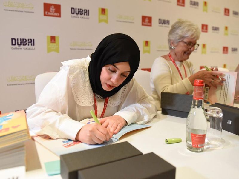 Ebtisam Al Beiti (L) signing her book 