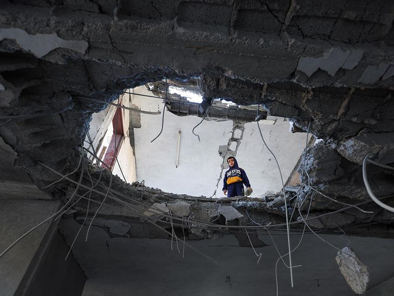 A Palestinian child looks on inside a damaged building at the site of an Israeli strike, in Rafah in the southern Gaza Strip on February 3, 2024. 