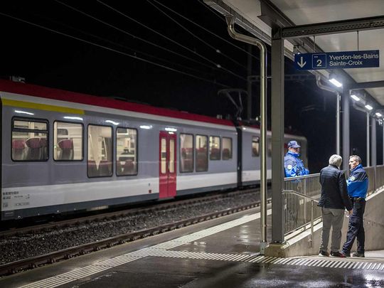 Swiss police officers stand next to a train