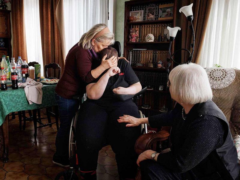 Lydie Imhoff (C) is hugged by friend and carer Marie Josee Rousseaux (L) and right-to-die activist Claudette Pierret during her farewell party in Longwy, northern France, on January 31, 2024.  