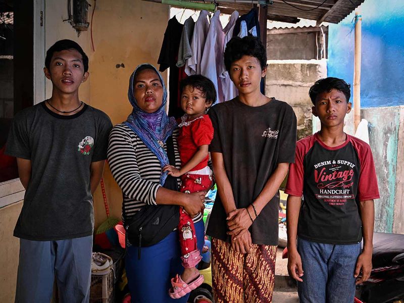 Ekawati posing with her children (from left) Yoga, Debi, Reza and Anip in front of their small rented home in Jakarta.  