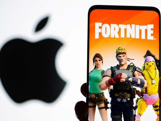 File photo: Fortnite game graphic is displayed on a smartphone in front of Apple logo in this illustration. 