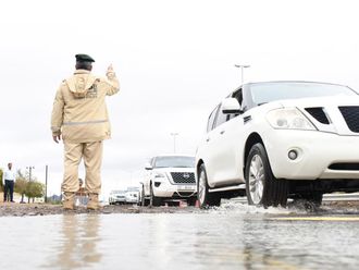 Dubai Police managing traffic on a road during the rain on Saturday